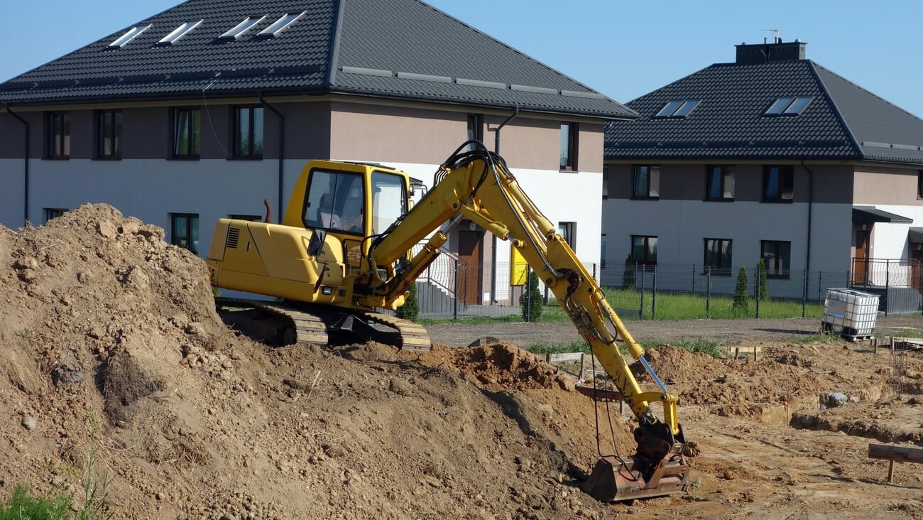 Crawler excavator on the construction site - work on the construction of the house has started; Shutterstock ID 2114787728