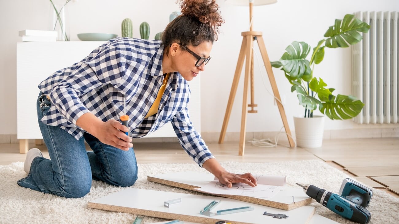 Black woman doing home improvements using screwdriver in new home; Shutterstock ID 2251326145