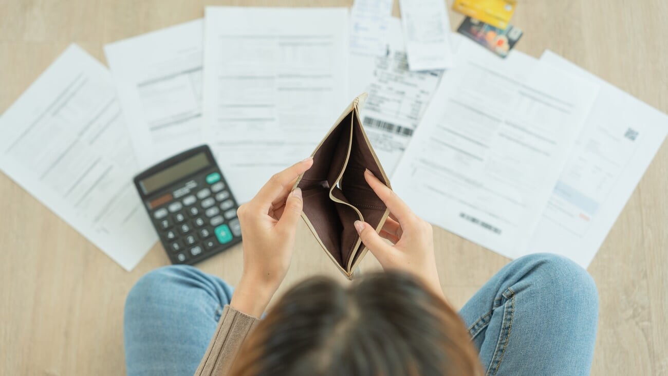 Stressed and headache woman with large bills or invoices no money to pay to expenses and credit card debt. shortage, Financial problem, bankruptcy, mortgage, loan, bankrupt, poor, empty wallet ; Shutterstock ID 2293566841