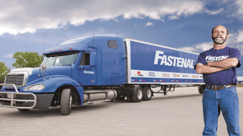 a man standing in front of a blue truck