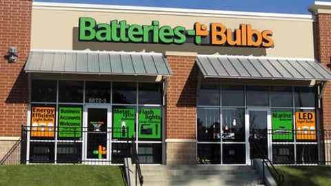 a large brick building with grass in front of a store