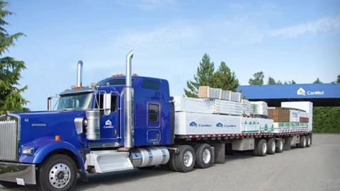 a large blue truck is parked on the side of a road