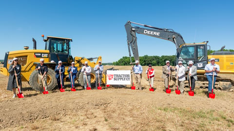 a group of people standing next to a tractor