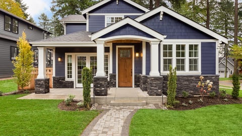 a house with a lawn in front of a brick building