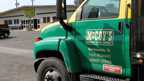 a green truck parked in front of a building