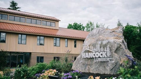 a house with bushes in front of a brick building