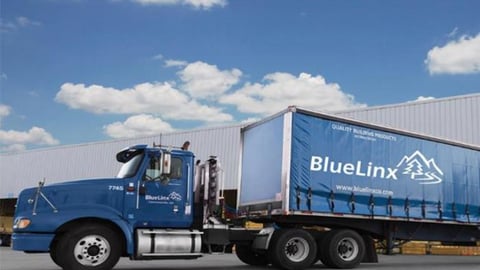 a large blue truck is parked on the side of a road