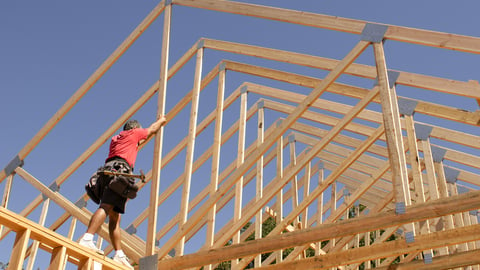 a person riding on top of a wooden fence