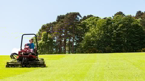 North Wales UK - May 21, 2014: Gardner on ride on lawn mower, concept lawn mower cutting grass with gardening tool.; Shutterstock ID 1733733383