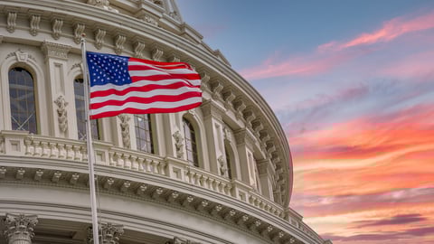 View of the United States Capitol Rotunda Dome in Washington DC with the Star Spangled American Flag against colorful dramatic sunset sky background; Shutterstock ID 1814961938