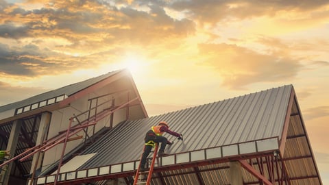 Roofer Construction worker install new roof,Roofing tools on during sunset,Electric drill used on new roofs with Metal Sheet.; Shutterstock ID 2020039871