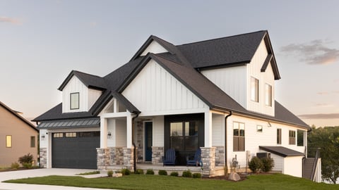 ELMHURST, IL, USA - SEPTEMBER 25, 2022: A black and white luxury home with a two car garage and black door, professional landscaping, and a lake in the background at sunset.; Shutterstock ID 2245365837