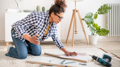 Black woman doing home improvements using screwdriver in new home; Shutterstock ID 2251326145