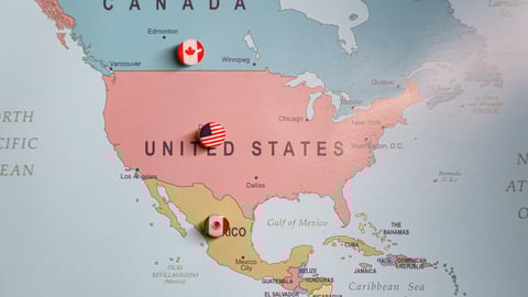 US flag push pin marking the United States on a map, with Mexico and Canada location pins visible. Tariffs. Trade wars. Import taxes. High quality photo; Shutterstock ID 2581009673