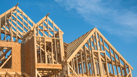 Close-up of gables roof on stick built home under construction and blue sky in Humble, Texas, USA. New build roof with wooden truss, post and beam framework. Timber frame house, real estate. Panorama; Shutterstock ID 721621315