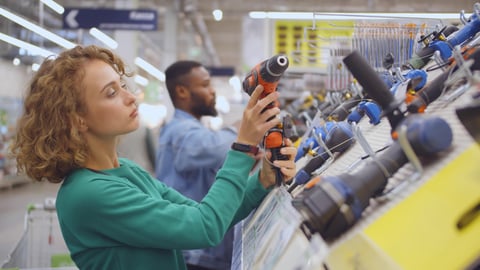 Young woman choosing electric screwdriver in hardware store. Side view of pretty lady examining electric drill in construction equipment department of diy shop; Shutterstock ID 1786814054