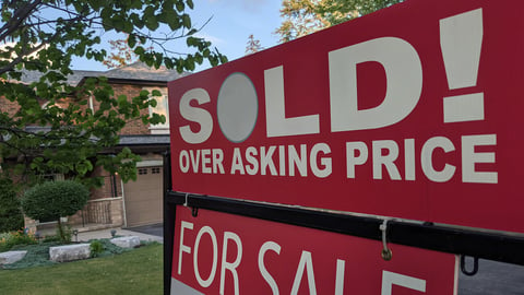 New sign sold over asking price for sale in front of detached house in residential area. Real estate bubble, crash, hot housing market, overpriced property, buyer activity concept. Selective focus.; Shutterstock ID 1998556205