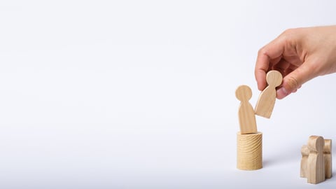 The man's hand of a businessman in a business suit holds a wooden figure of a man in his hand and moves another figure from his post. The concept of firing an employee, the replacement of staff Banner; Shutterstock ID 1101685712