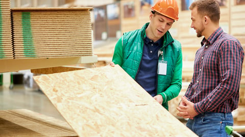 warehouse worker show the best variant of wooden board in their market, customer looking for building material; Shutterstock ID 1714746892