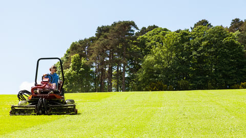 North Wales UK - May 21, 2014: Gardner on ride on lawn mower, concept lawn mower cutting grass with gardening tool.; Shutterstock ID 1733733383