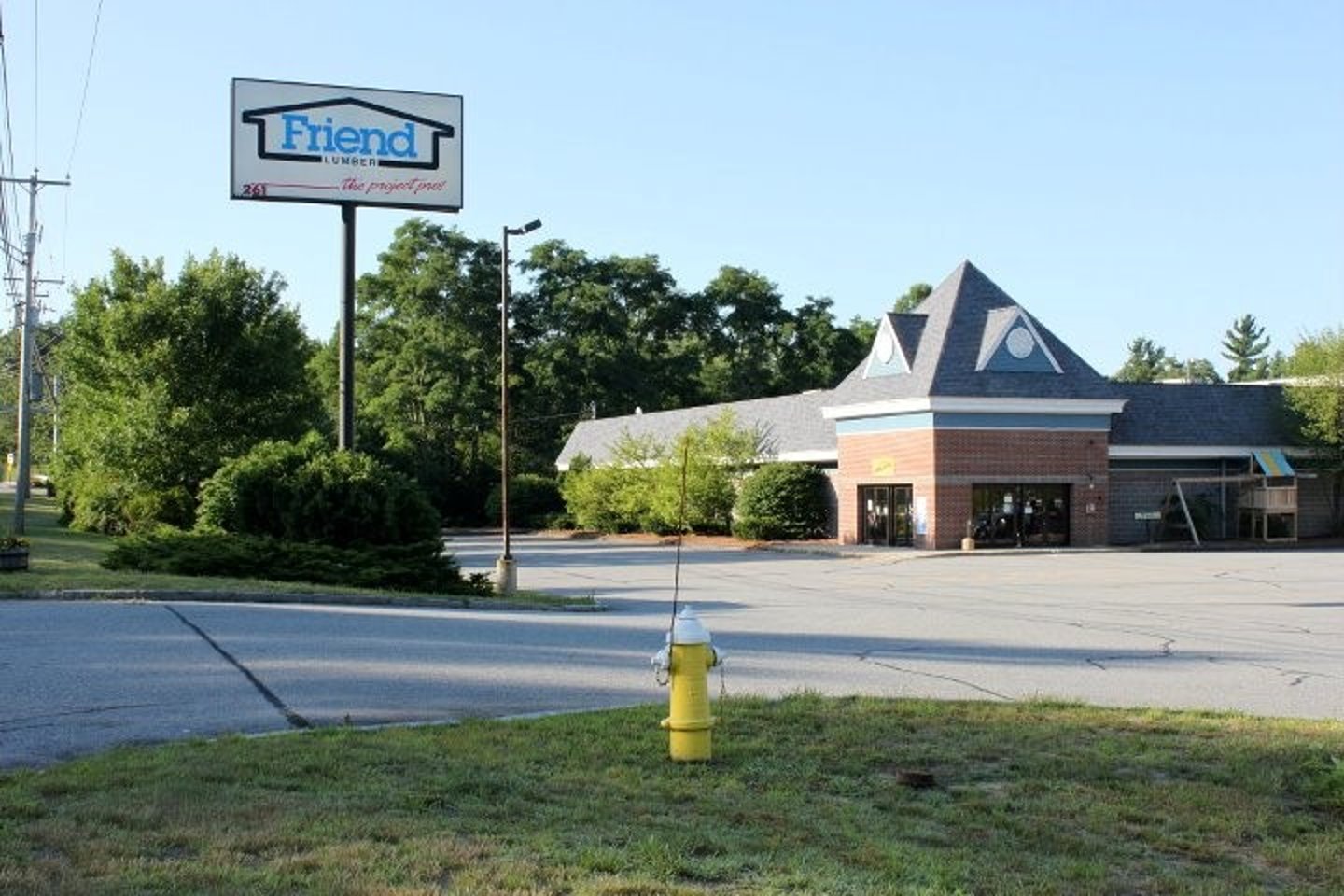 a sign over a fire hydrant sitting on the side of a road