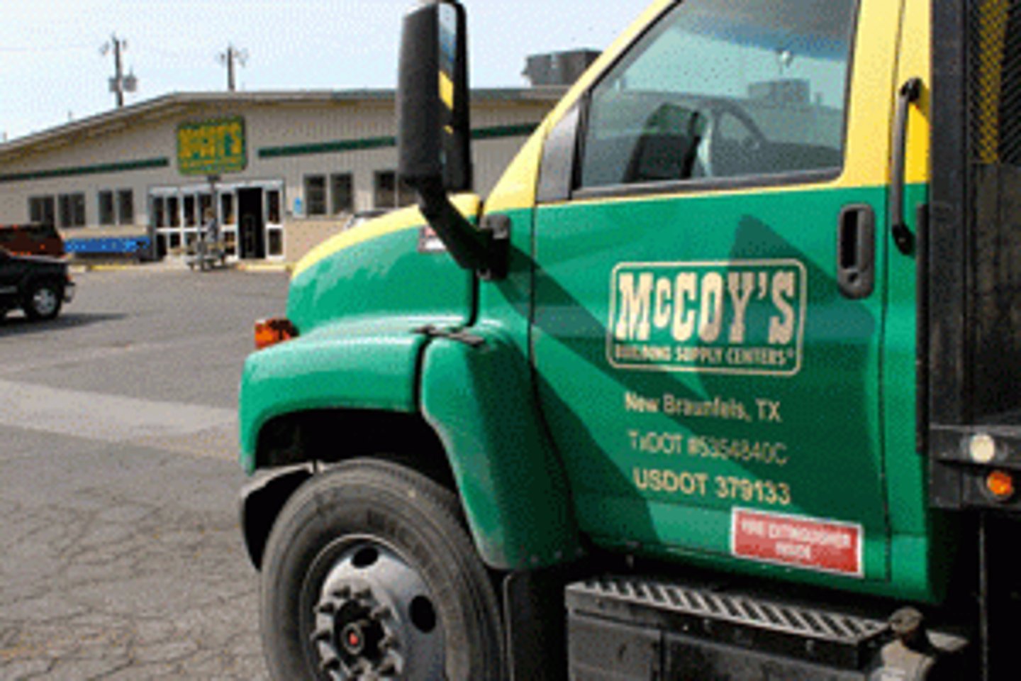 a green truck parked in front of a building