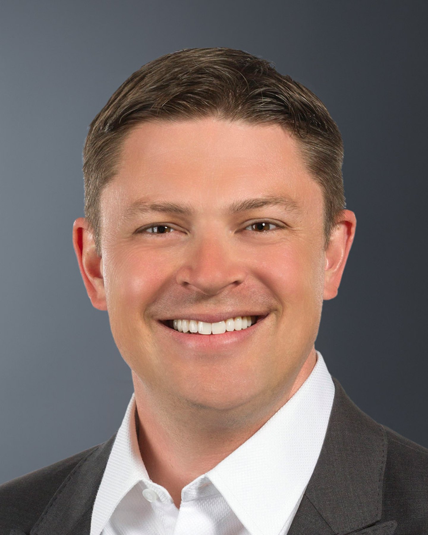 a man wearing a suit and tie smiling at the camera