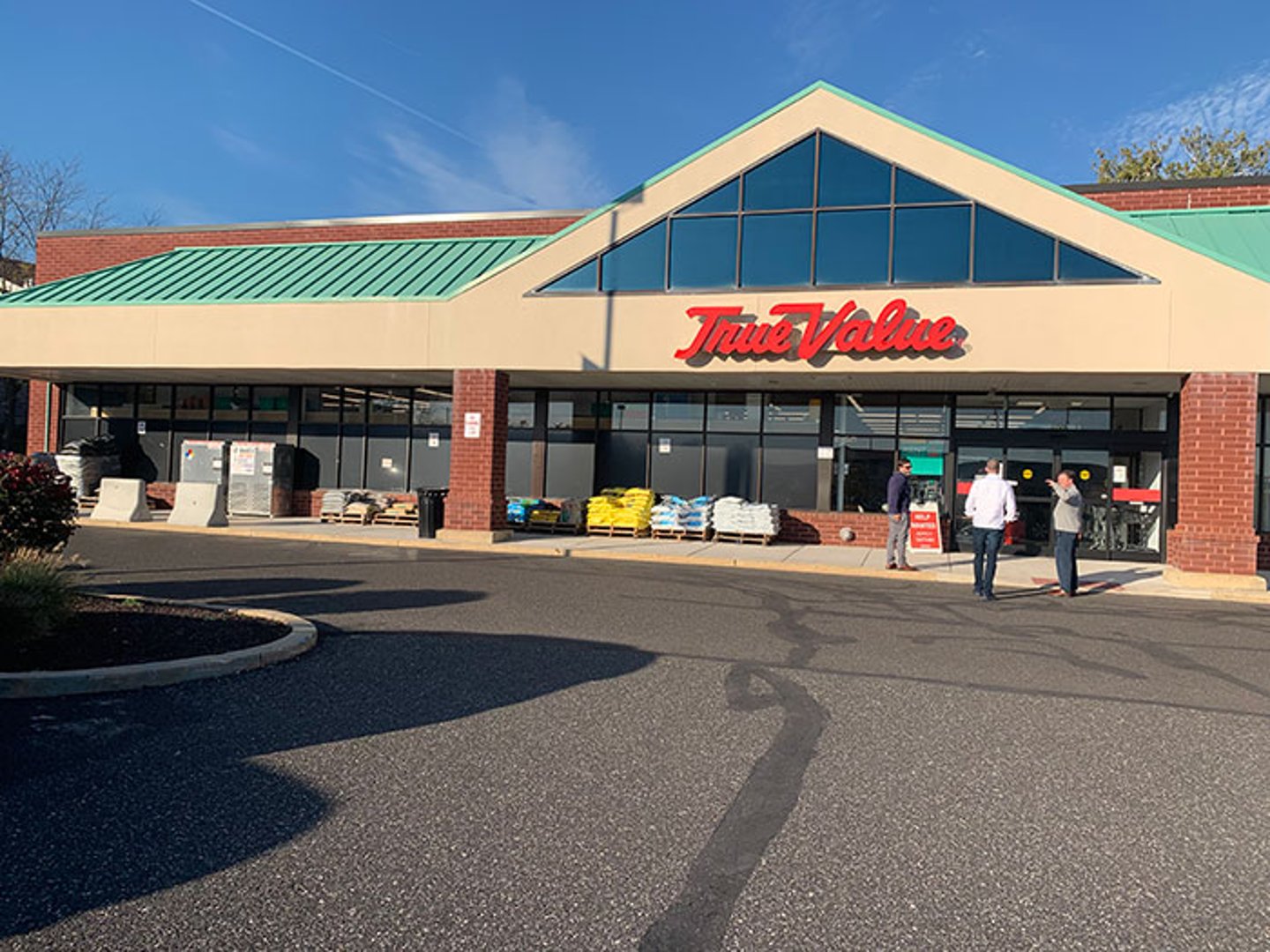 a group of people standing in a parking lot in front of a building