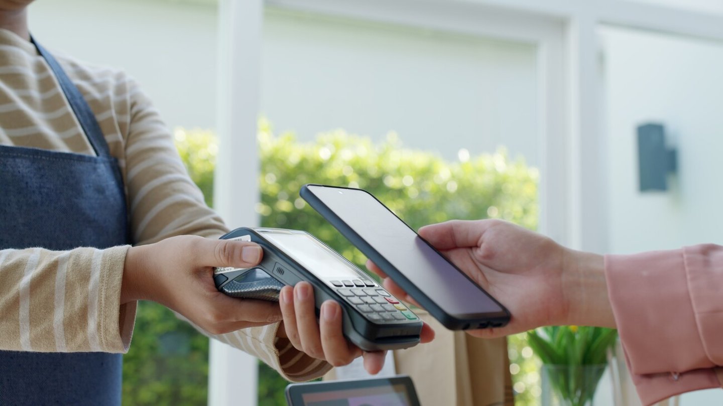 Close-up hand asia woman people work in small sme coffee cafe shop store owner use cashless wifi paywave nfc scan app smart pos reader sale in take out food drink order in urban city life contactless.; Shutterstock ID 2059763165