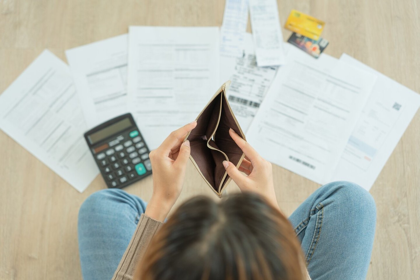 Stressed and headache woman with large bills or invoices no money to pay to expenses and credit card debt. shortage, Financial problem, bankruptcy, mortgage, loan, bankrupt, poor, empty wallet ; Shutterstock ID 2293566841
