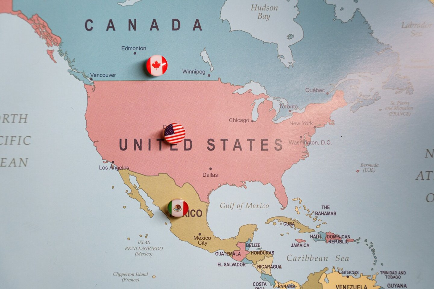 US flag push pin marking the United States on a map, with Mexico and Canada location pins visible. Tariffs. Trade wars. Import taxes. High quality photo; Shutterstock ID 2581009673