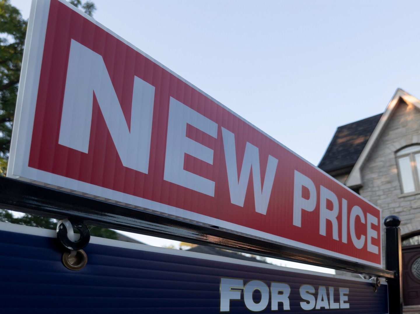 Sign for sale new price by detached house in residential area. Real estate market volatility,  bubble, crash, hot and cooling housing market, overpriced property, buyer activity concept.  ; Shutterstock ID 2172645745