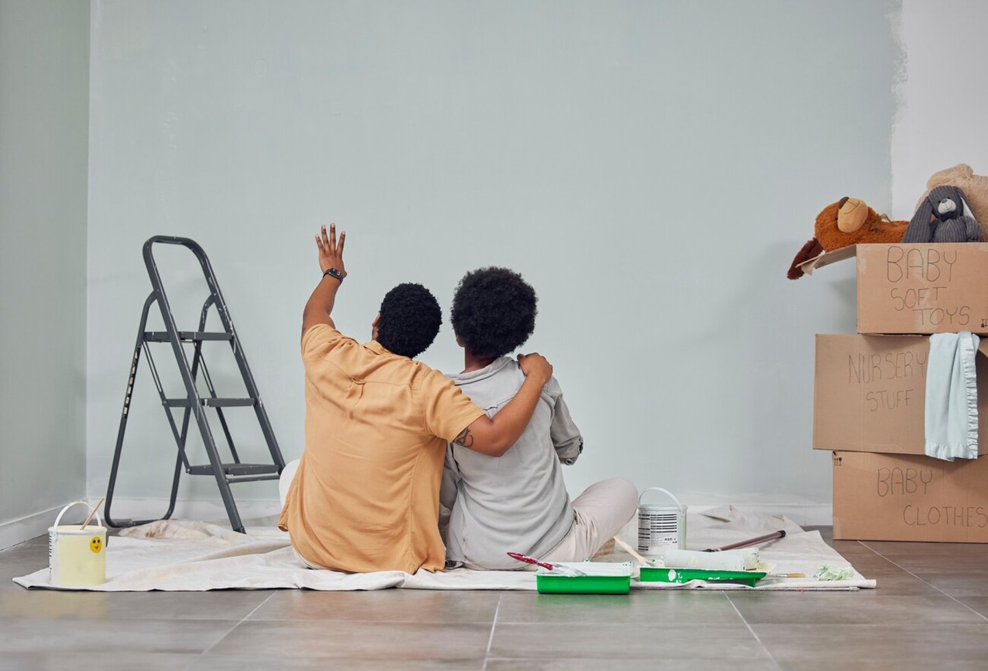 Planning, wall or black couple pointing in home renovation, diy or house remodel together on floor. Back view, painting or African man loves talking or working with teamwork in decoration with woman; Shutterstock ID 2265499721