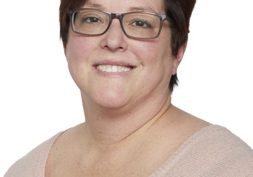 a person wearing glasses and smiling at the camera