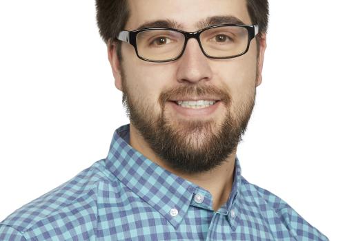 a man wearing glasses and looking at the camera
