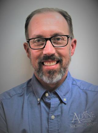 a man wearing glasses and looking at the camera