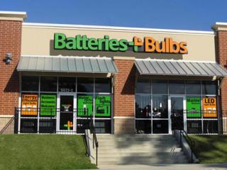 a large brick building with grass in front of a store