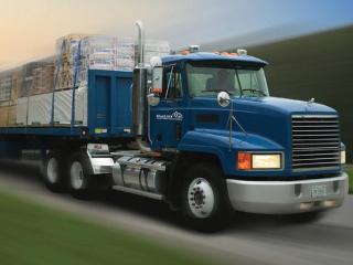 a large blue truck is driving down the road