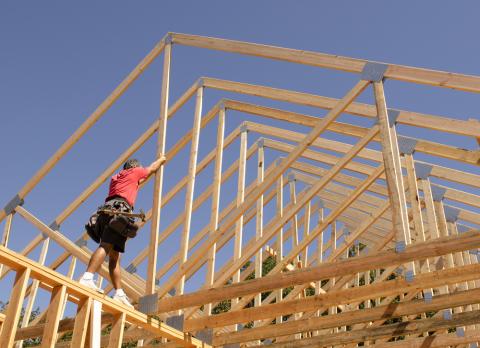a person riding on top of a wooden fence