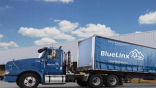 a large blue truck is parked on the side of a road